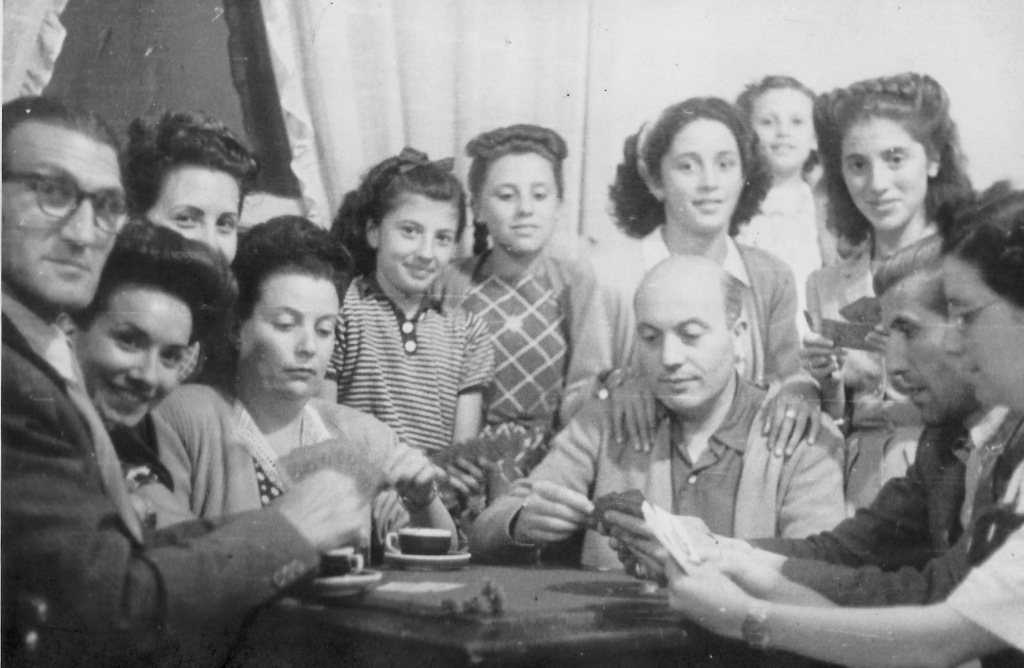 Jugant a cartes. A l’esquerra mirant la càmera n’Antoni Pomés, al seu costat
na Carme Puiggené esposa d'en Timoteu Pomés, i na Júlia Pomés, a la dreta n’Arcadi Pomés jugant a cartes amb altres
familiars. Al fons amb el sueter a ratlles na Núria Pomés Fontanetfilla de l'Arcadi. (Fotografia realitzada per en Timoteu Pomés i
cedida per n’Aurora Maquinay Pomés). Aprox. 1945.